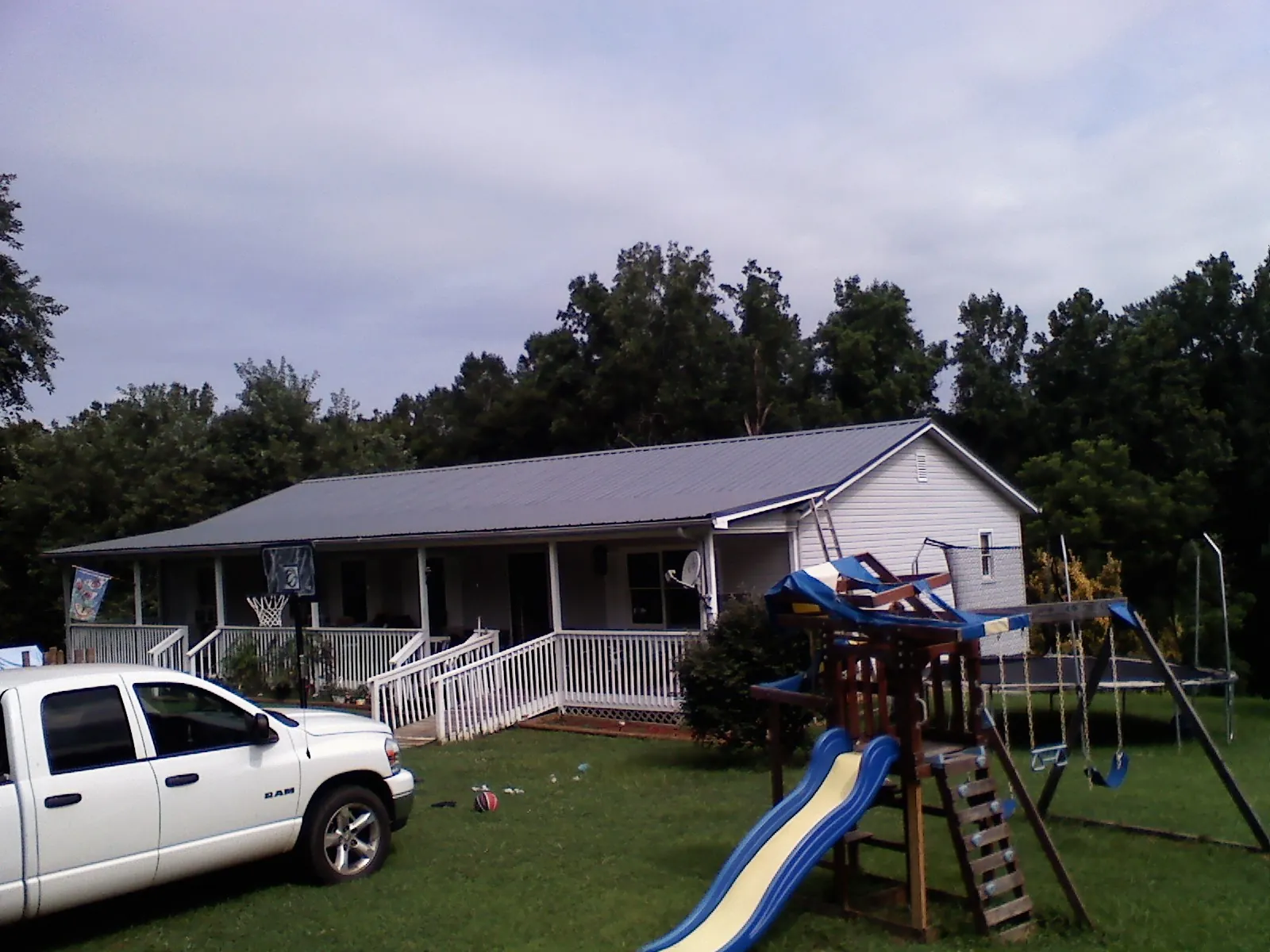 Dark metal roof on a country home with a full length front porch in Collinsville